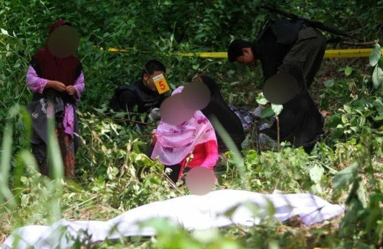 تايلاند والمسلمون المطالبون بالاستقلال يتفقون على خطة جديدة لإنهاء العنف 2 أقارب يجلسون بجوار جثة انفصالي مسلم مشتبه به في مقاطعة يالا بجنوب تايلاند .