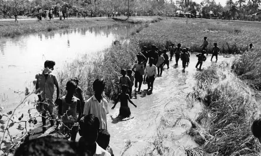 لماذا تنفد الخيارات في بنغلاديش في مواجهة الطقس القاسي؟ 2 أطفال في بولا، أكبر جزيرة في بنجلاديش، يخوضون مياه . الفيضانات في أعقاب إعصار بولا، الذي أودى بحياة ما يصل إلى 500 ألف شخص في عام 1389ه ( 1970م ) .