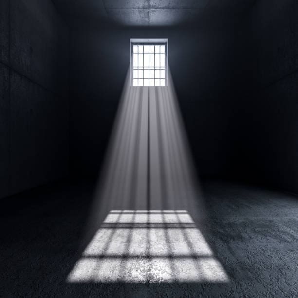 inside a prison light coming from a window with bars